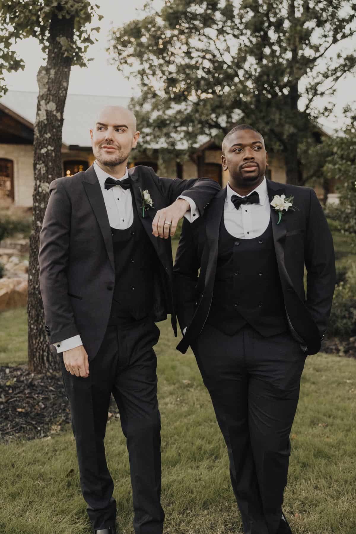 two gay grooms posing in tuxedos